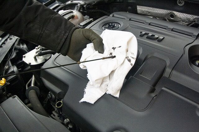 mechanic checking car engine oil