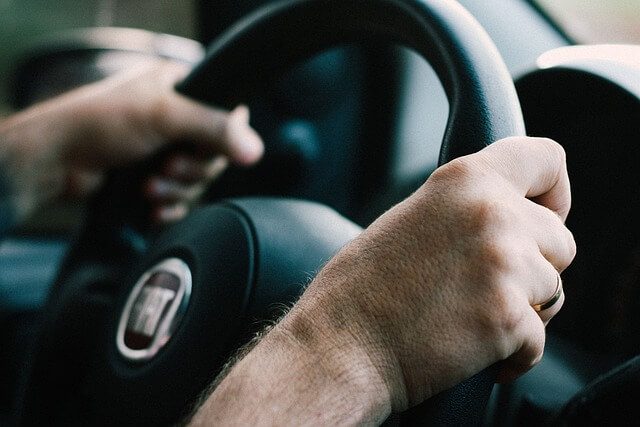 adult driving car steering wheel